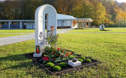 Moderner Grabstein eines Urnengrabes aus Kalkstein – Halbrund mit Öffnung – Grabgesta...