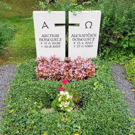 Moderne Grabanlage mit hellem zweiteiligem Doppelgrabstein aus Kalkstein - pflegeleichte Grabbepflanzung mit Bodendeckern & Sommerblumen