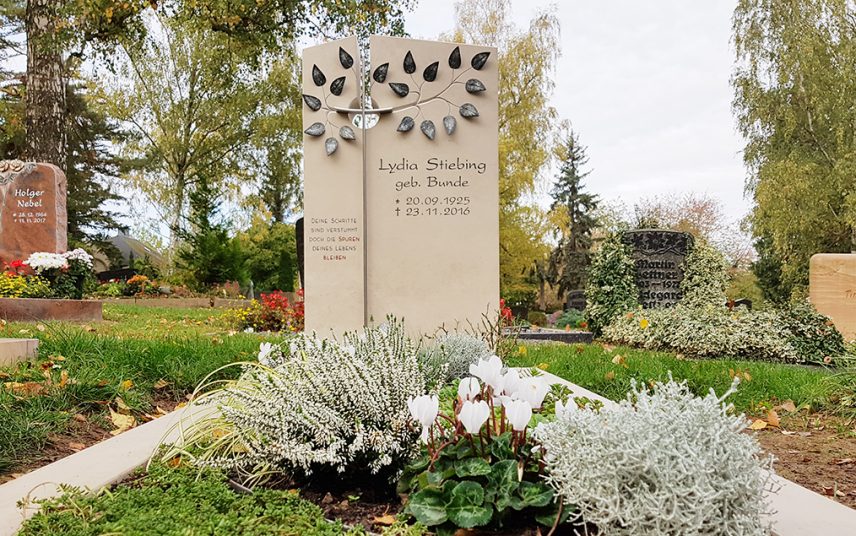 Grabmal für ein Einzelgrab aus Kalkstein mit Grabumfassung – moderne Grabgestaltung mit schöner Grabbepflanzung