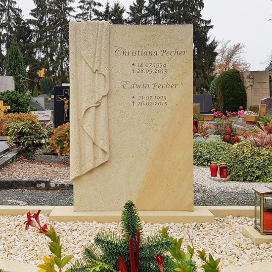 Großer Grabstein mit Einfassung für ein Doppelgrab aus Sandstein mit gemeißeltem Grabtuch - moderne Grabgestaltung mit Kies und Grablaterne aus Bronze