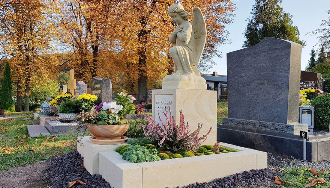 Urnengrab Gestaltung mit Grabengel aus Sandstein & Grabbepflanzung immergrün