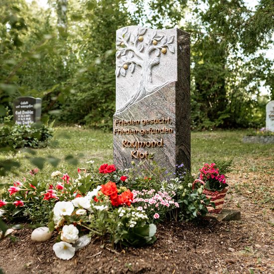 Romantisches Granitgrabmal mit Baum & vergoldeten Früchten - sommerlicher Blumenschmuck umrahmt den Grabstein