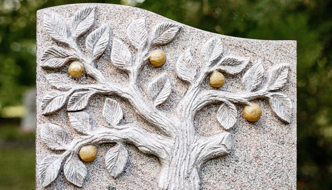 Romantisches Granitgrabmal mit Baum & vergoldeten Früchten - sommerlicher Blumenschmuck umrahmt den Grabstein
