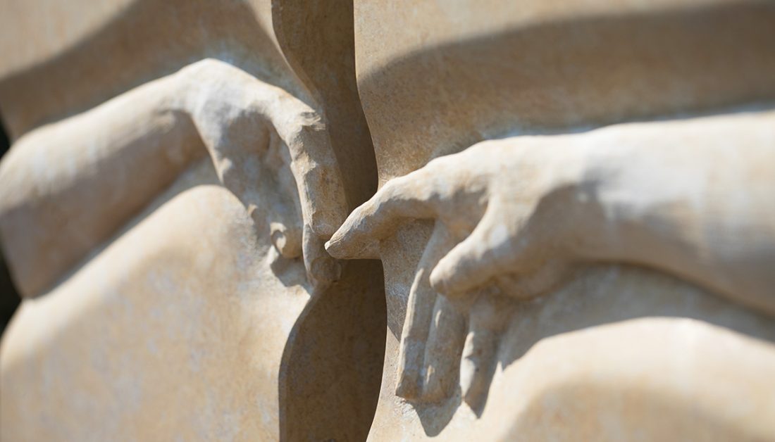 Einzelgrab Idee – Geteiltes Einzelgrab aus Marmor in Sandsteinoptik mit sich reichenden Händen – Grabeinfassung & Abdeckplatte bestimmen die pflegeleichte Gestaltung