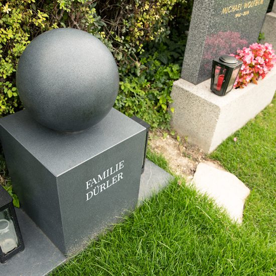 Idee für ein modernes Grabdenkmal - Reduziert modernes Grabmal aus dunklem Granit - Kugel & Quader bestimmen die Form - Grablaternen