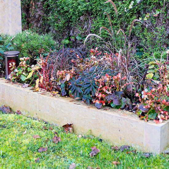 Gestaltungsidee eines Einzelgrabes im klassischen Stil mit Einfassung und pflegeleichtem Bepflanzungsplan für den Herbst