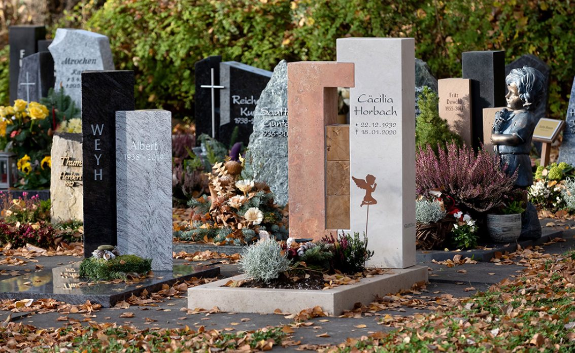 Moderner Urnengrabstein aus hellem Kalkstein und Rotem Travertin mit Holzwürfeln verbunde...