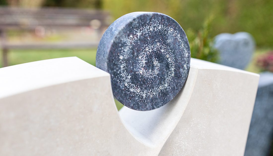 Beispiel Grabgestaltung eines modernen Urnengrabmales aus Kalkstein mit Kristallen – winterliche Grabeindeckung mit Reisig & Blumen