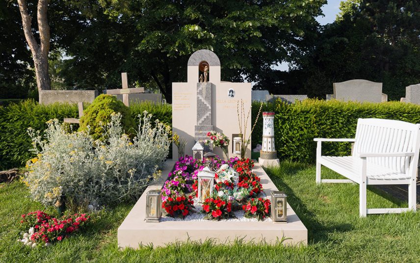 Moderner Doppelgrabstein aus einem Materialmix von Kalkstein & Granit – symmetrische Grabgestaltung mit Sommerblumen Gabschmuck und Zierkies