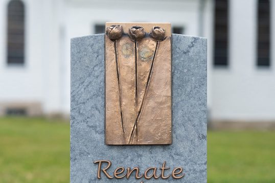 Grabgestaltungsidee eines modernen Urnengrabmales aus Granit mit Bronzetafel – Sommerbepflanzung mit pflegeleichten Zierpflanzen