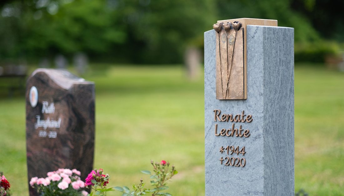 Grabgestaltungsidee eines modernen Urnengrabmales aus Granit mit Bronzetafel – Sommerbepflanzung mit pflegeleichten Zierpflanzen