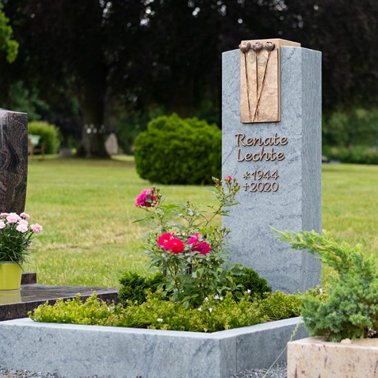 Grabgestaltungsidee eines modernen Urnengrabmales aus Granit mit Bronzetafel - Sommerbepflanzung mit pflegeleichten Zierpflanzen