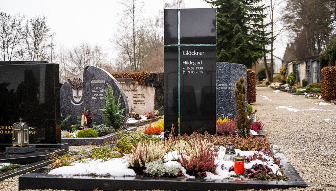 Gestaltungsidee Doppelgrab aus schwarzem Granit mit Glaskreuz  Einfassung und Bepflanzung