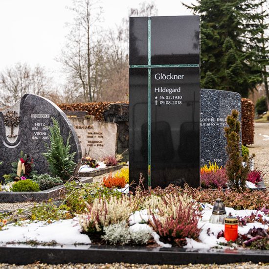 Gestaltungsidee Doppelgrab aus schwarzem Granit mit Glaskreuz  Einfassung und Bepflanzung