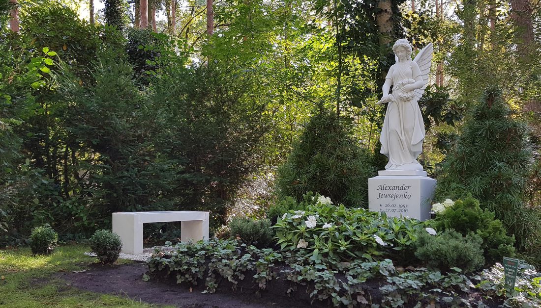 Großes Familiengrab mit einem Marmorengel als Grabstein - immergrüne Ganzjahresbepflanzung