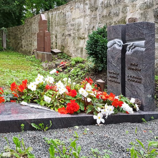 Grabanlage mit zweiteiligem Doppelgrabstein  Einfassung und Abdeckplatte aus poliertem Granit - Symbol der sich reichenden Hände / pflegeleichte Grabbepflanzung mit Sommerblumen