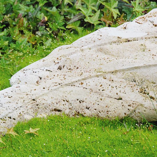 liegender Grabstein aus Travertin - Engelsflügel - freie Grabgestaltung mit Bärenfellgras und bunten Herbstblumen