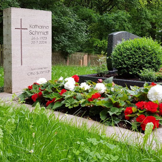 Schlichter Grabstein aus hellem Kalkstein mit Gravur und Grabumfassung - Grabbepflanzung für den Sommer mit roten & weißen Blumen