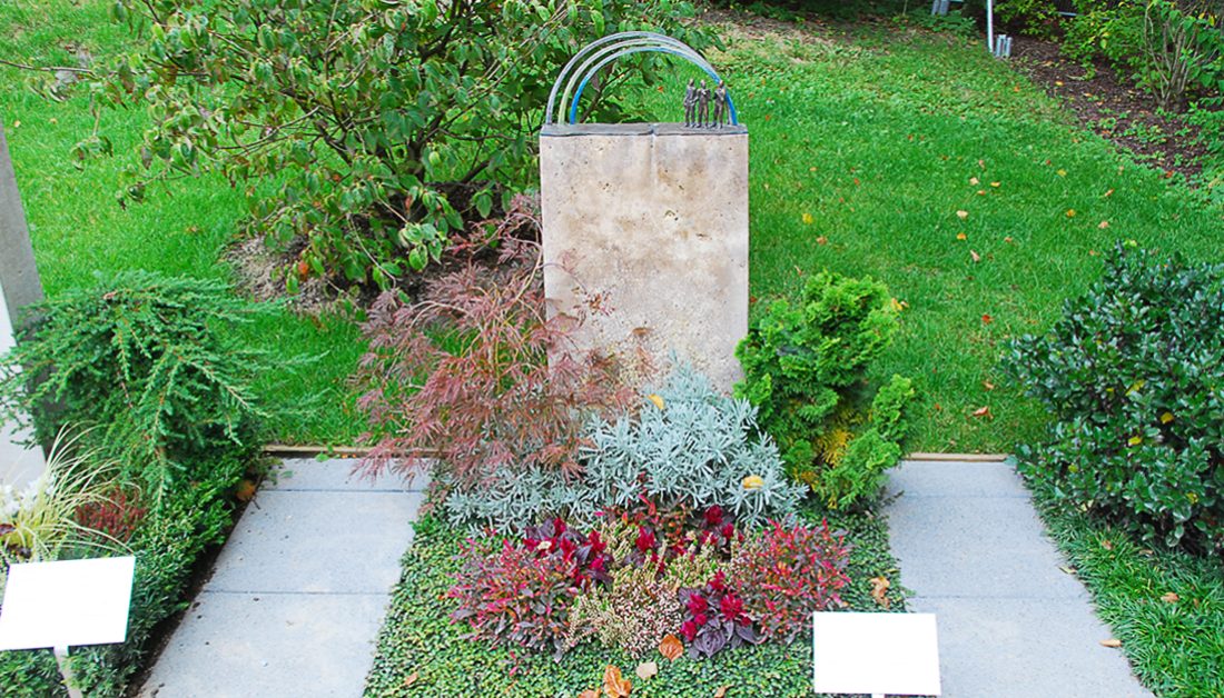 Grabgestaltung Idee modernes Einzelgrab mit Grabstein aus Travertin und Regenbogen aus Bronze - pflegeleichte ganzjährige Grabbepflanzung 