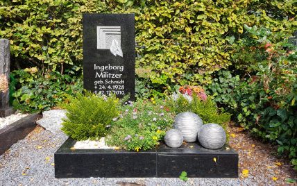 Kleines modernes Urnengrab aus schwarzem Granit- gestaltet mit einer Sommerbepflanzung  Ki...