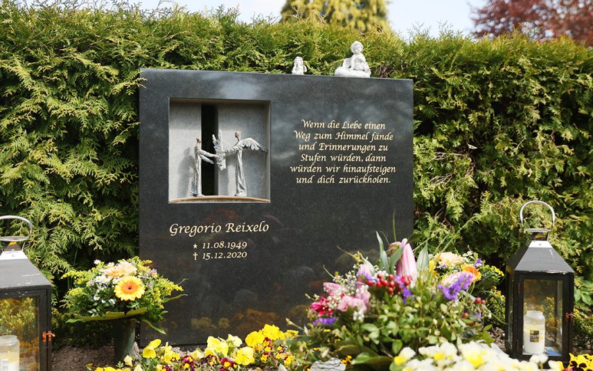 Doppelgrab mit modernem Grabstein aus schwarzem Granit & Treibholz – pflegeleichte Grabbepflanzung mit Immergrün und Nadelgehölz