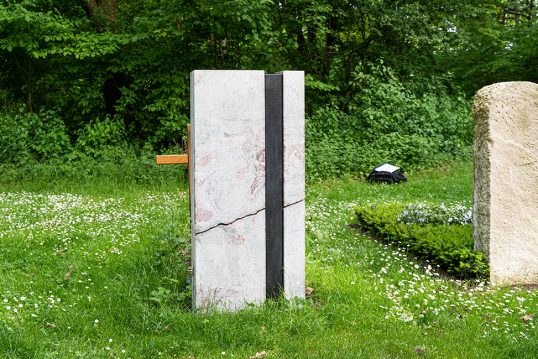 Moderner Grabstein für ein Doppelgrab aus buntem Marmor mit angerauter Oberfläche und aufgesetzten Aliminium Schrift