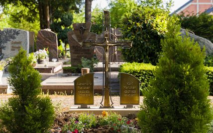 Klassische Doppelgrabanlage mit einem schmiedeeisernen Grabkreuz und Bronzetafeln – Grab...