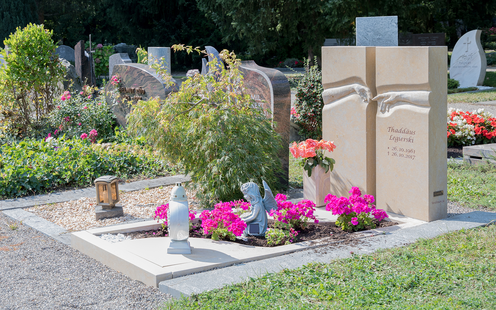 Idee für die Gestaltung eines sonnig gelegenen Grabs mit pinken Blumen und Grabdekoration.