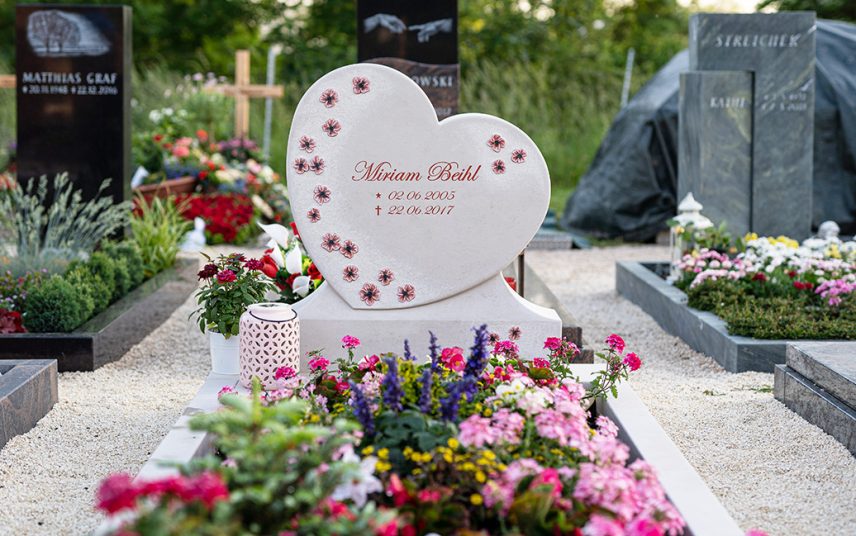 Einzelgrabmal in Herzform aus hellem Kalkstein auf dem Friedhof Sersheim mit Sockel  Einfassung und Grablaterne