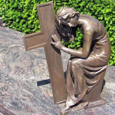 Trauernde Bronzefrau lehnt sich an Kreuz Tirina