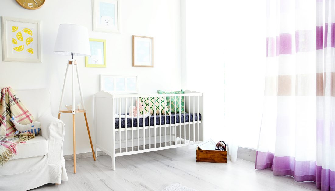 Idee für die erste Kinderzimmereinrichtung für dein Baby - Wohnideee im Landhausstil - weißes Sofa und Kinderbettchen & Eine Stehlampe sorgt für behagliches Licht 