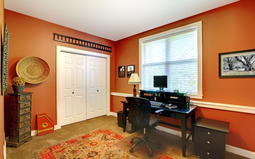 Arbeitszimmer Idee – Klassisch amerikanisches Arbeitszimmer – warme Wandgestaltung in orange kombiniert mit dunklem Holzschreibtisch & Ablageschrank