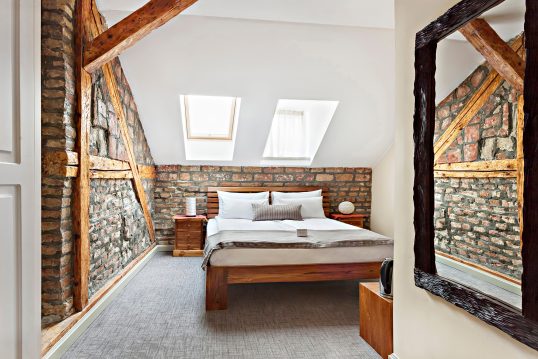 Schlafzimmer mit Cottagefeeling im Dachgeschoß – Landhausstyle mit Ziegelsteinwand und modernes D...