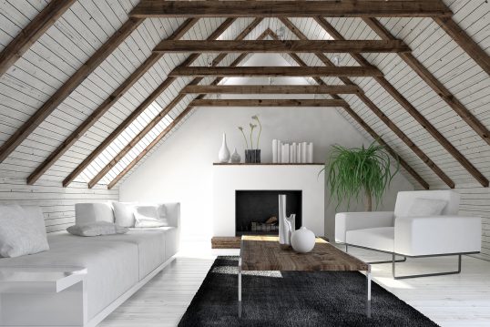Dachzimmer im Landhausstil Einrichtungsidee – Wohnzimmereinrichtung mit moderner Couch & Sessel aus weissem Stoff vor offenem Kamin