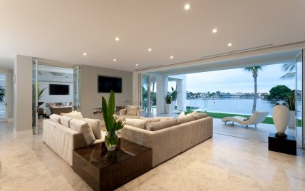 Schickes Wohnzimmer einer Villa mit Panoramafenster zur Terrasse  Ethanolkamin & Natursteinboden –...