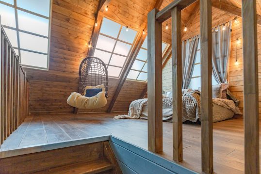 Offener Schlafbereich im Dachgeschoß mit Doppelbett und Hängesessel – Ferienwohnung im Landhauss...