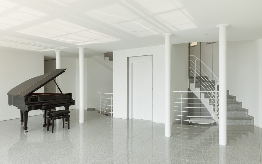 Musikzimmer im offenen Wohnbereich – reduzierter moderner Bauhauslook im Industriedesign mit Säulen und Granitboden