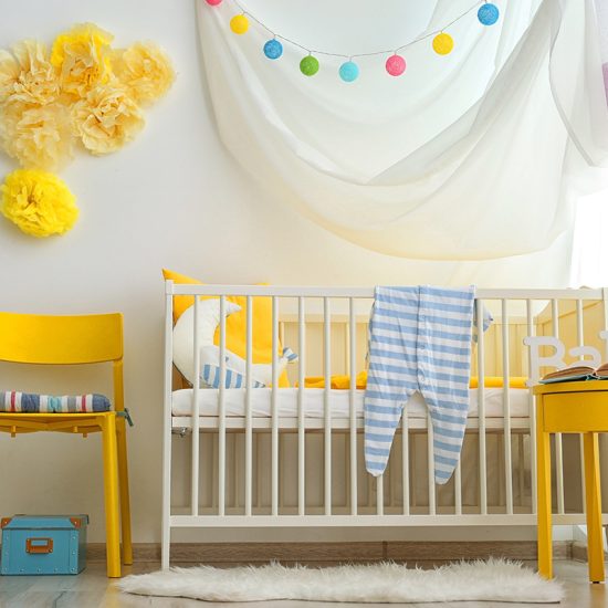 Babyzimmer für Mädchen Idee mit weißen Babybett  gelben Stuhl & gelbe Schränkchen - interessante Wandgestaltung mit gelben Tüll zum nachmachen - bunte Lichterkette 