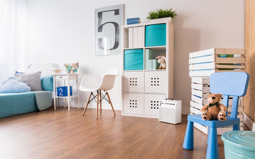 Modernes Kinderzimmer für Jungen mit blauen Akzenten – weißes Regal & weißer Schalenstuhl – Futonbett kombiniert mit weißen Nachtschrank – Wandgestaltung mit großem Bild