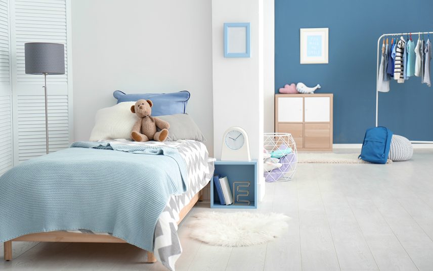 Kinderzimmer Gestaltungsidee für Mädchen & Jungs mit blauer & weißer Wandgestaltung – Einzelbett mit blauer Kinderbettwäsche – Nachtschrank in Kastenform mit Wecker – Holzschrank & Stehlampe