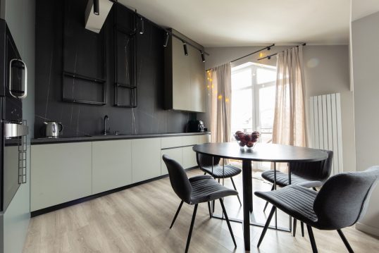 Dunkle industriell eingerichtete Küche als Wohnidee – Beispiel mit schwarzer Wandgestaltung & hel...