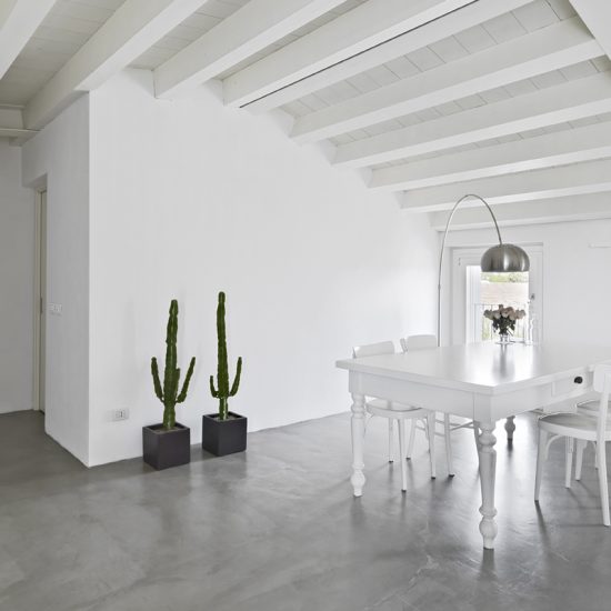 Helles Esszimmer ganz in weiß als Einrichtungsidee - Beispiel mit barocken Tisch & weißen Holzstühlen - Zimmerpflanzen in Pflanzgefäßen - silberne Bogenlampe