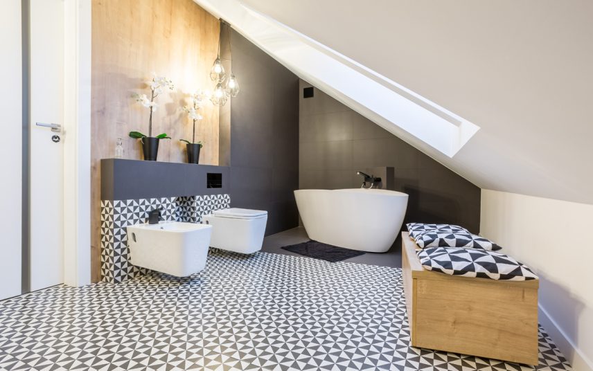 Moderne Einrichtungsidee für ein Bad im Dachgeschoss – Beispiel mit freistehender Badewanne & Holzbank – schwarz-weiße Wandfliesen & Holzakzente