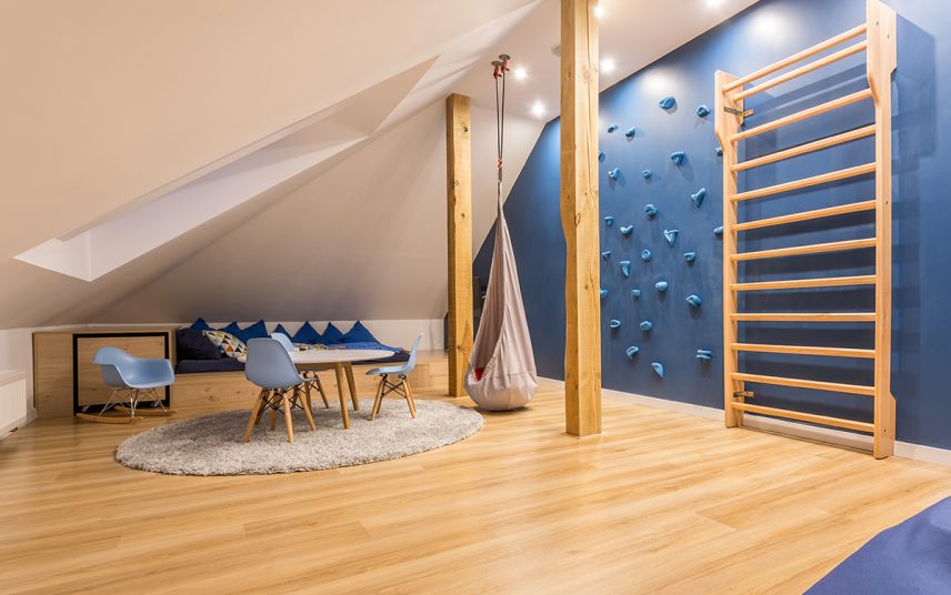 Skandinavische Einrichtungsinspiration für ein großes Kinderzimmer mit blauer Kletterwand unter dem Dach – Beispiel mit Schalenstühlen & runden Tisch – Holzbett & Schaukelstuhl