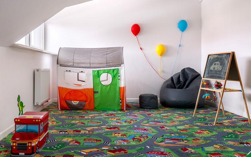 Idee für ein Kinderzimmer unter der Dachschräge – Beispiel mit tollen Kinderteppich & Spielhaus – schwarzer Sitzsack & Kinderlampen in Form von Ballons