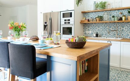 Schöne Küchengestaltung mit einer Kochinsel als Küchentisch & Barhockern – Beispiel mit Dekorat...