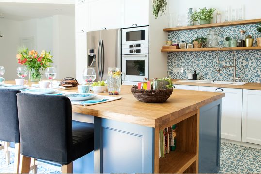 Schöne Küchengestaltung mit einer Kochinsel als Küchentisch & Barhockern – Beispiel mit Dekoration in der Küche  Glasvase & Blumenstrauß