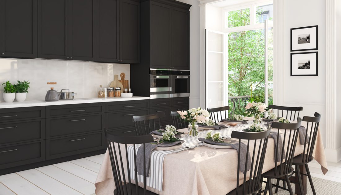 Geräumige schwarze Küche mit sommerlich gedecktem Esstisch als Inspiration - Beispiel mit moderner Esstisch Deko - pinke Tischdecke & Tischläufer - große Servietten & Glasvasen mit Blumen