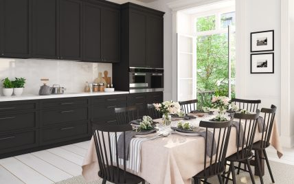 Geräumige schwarze Küche mit sommerlich gedecktem Esstisch als Inspiration – Beispiel mit modern...