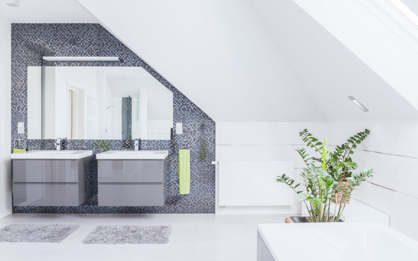Gestaltungsidee für ein modernes Badezimmer – Beispiel mit großen Badspiegel & Waschbeckenunterschränken – Wandgestaltung mit Fliesen – Spiegelleuchte & Badtextilien